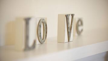 A white shelf with metallic letters spelling "LOVE" in a minimalist style.