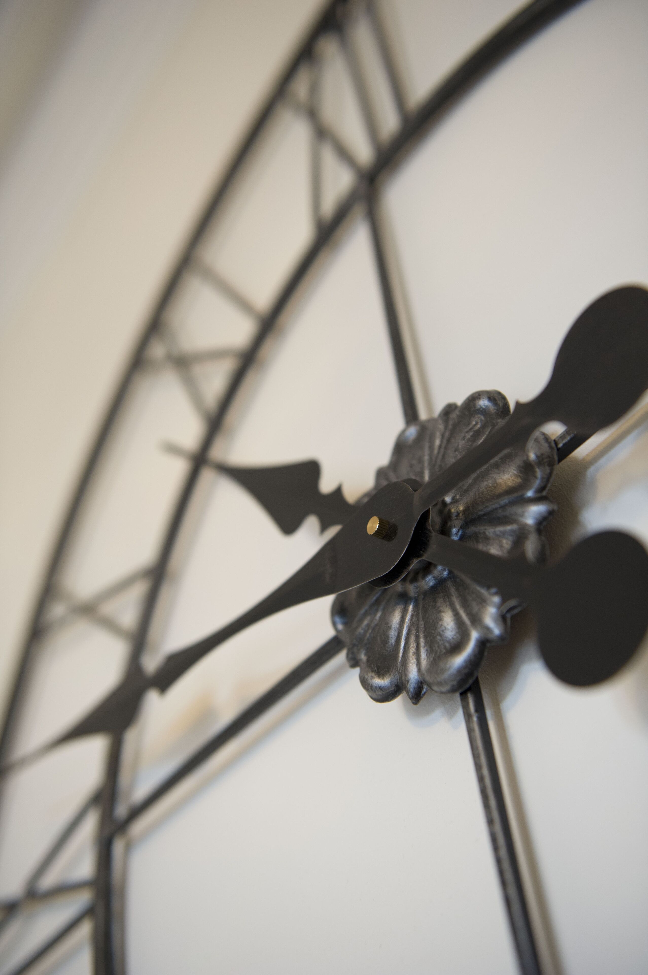 A close-up of a decorative clock with a floral design, featuring a black and white color scheme.