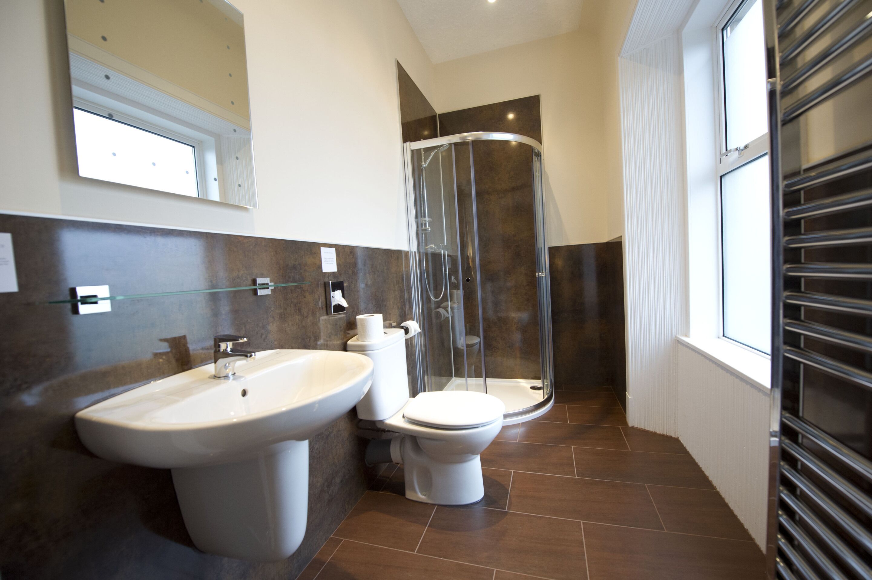 Un bagno moderno con cabina doccia in vetro, un lavandino spazioso e un water.