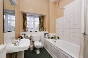 A bathroom with a toilet, sink, and bathtub. - The Old School (Bicester)