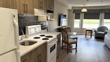 Deluxe Room, 1 Queen Bed, Kitchen (Spa Tub) | Private kitchen | Full-sized fridge, oven, stovetop, cookware/dishes/utensils