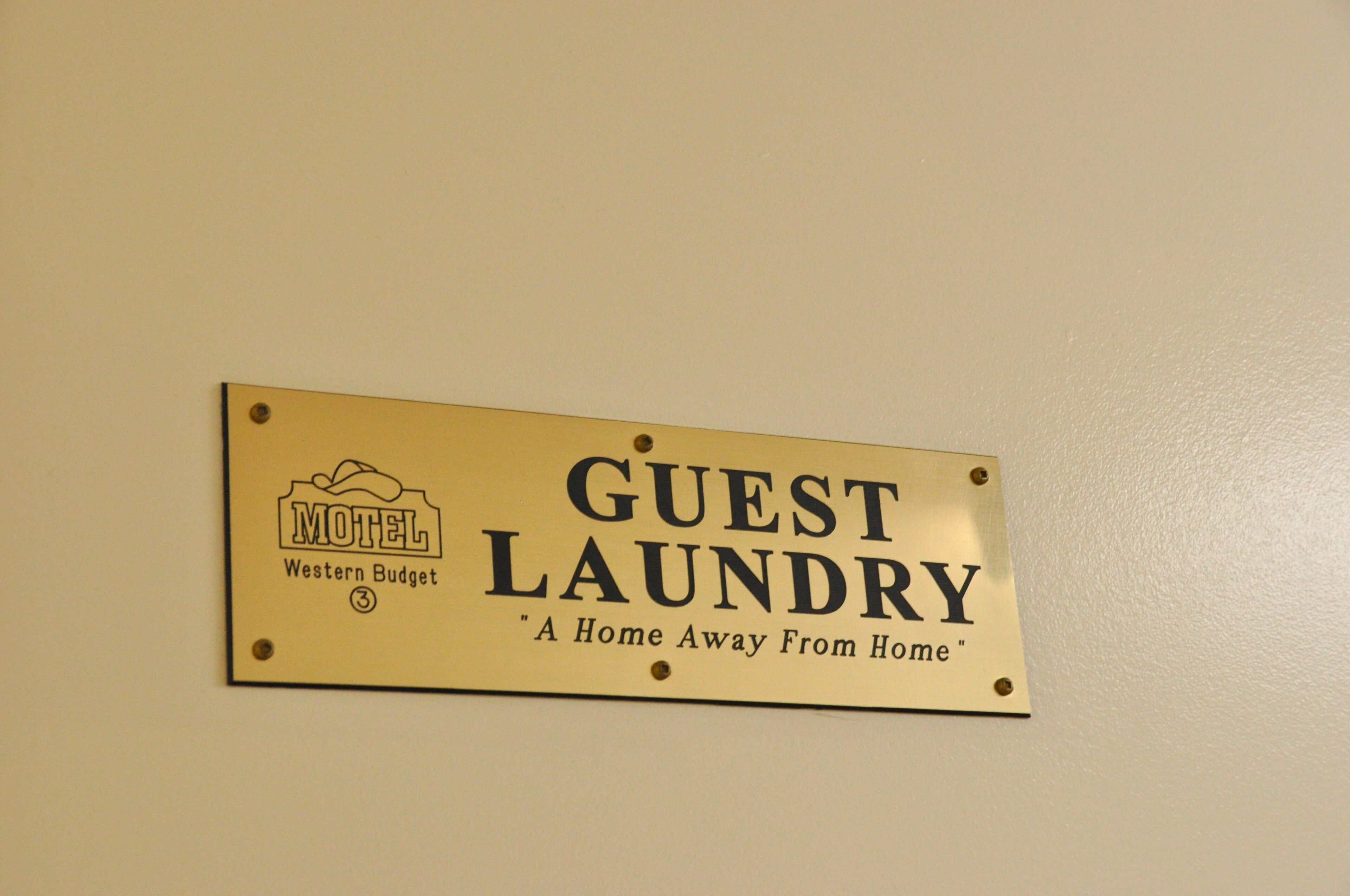 Señalización de lavandería para huéspedes en un motel, indicando una experiencia como estar en casa.