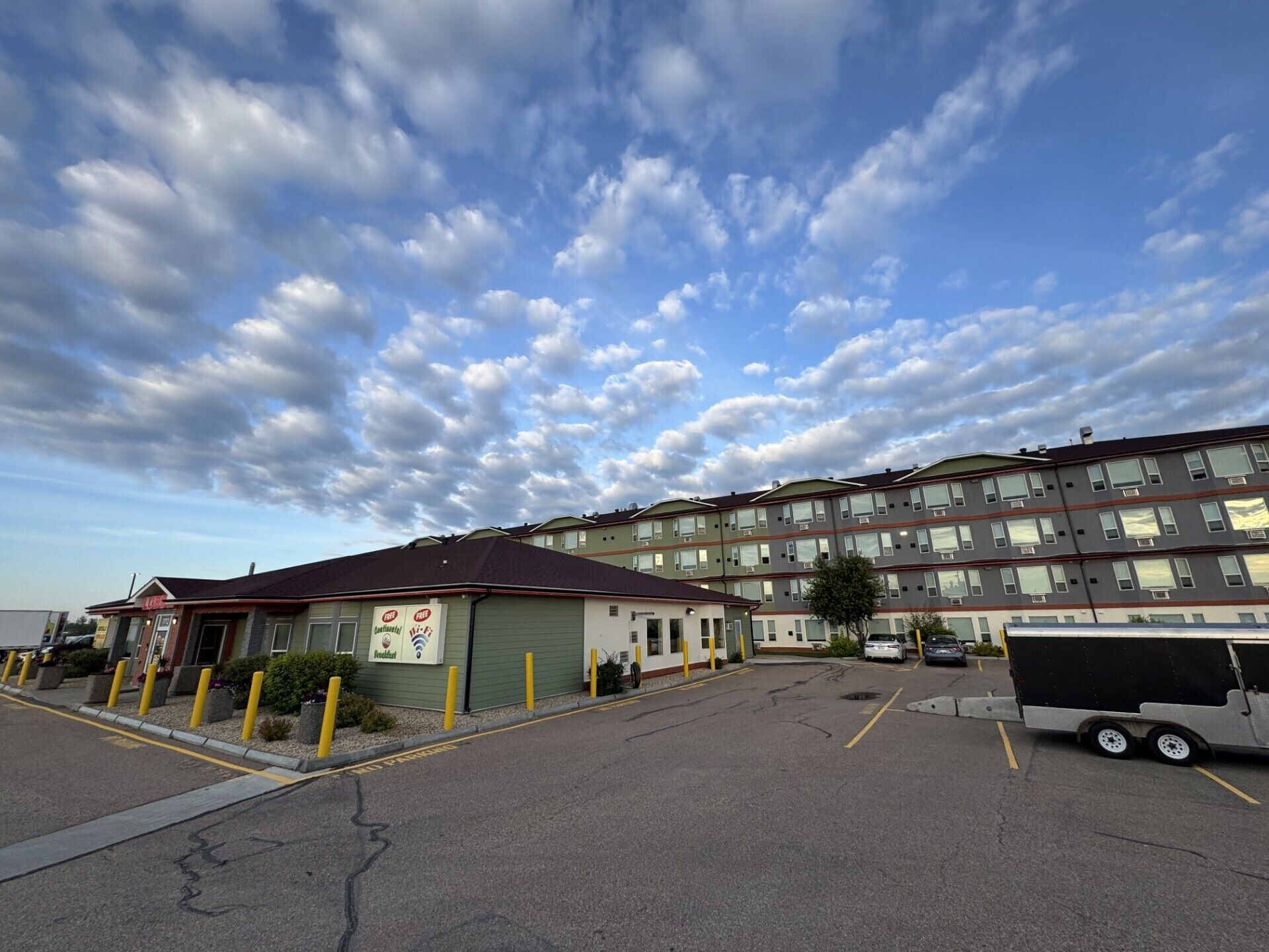 A parking lot with a building featuring a sign for a free Wi-Fi service.