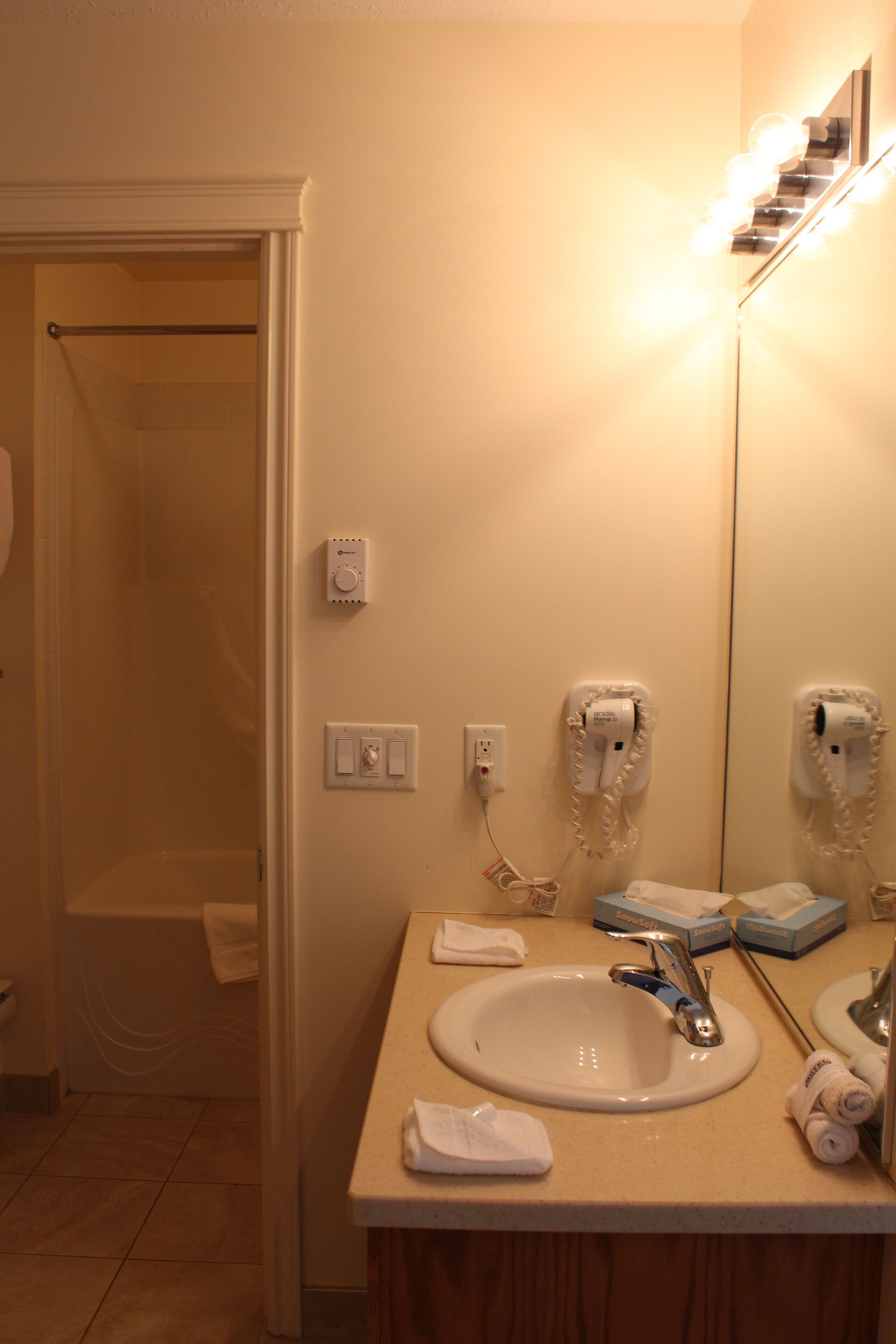 A bathroom with a sink, mirror, towel rack, and hairdryer.