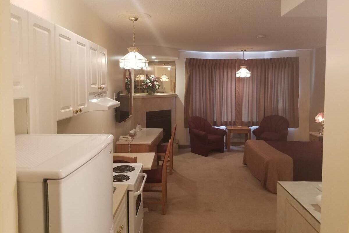 A compact living space with a kitchenette, dining area, and seating.