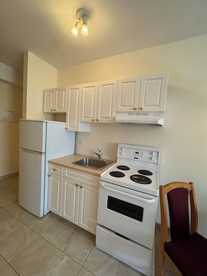 Camera Deluxe, 1 letto queen | Cucina privata | Frigorifero con congelatore, forno a microonde nell'area comune, forno