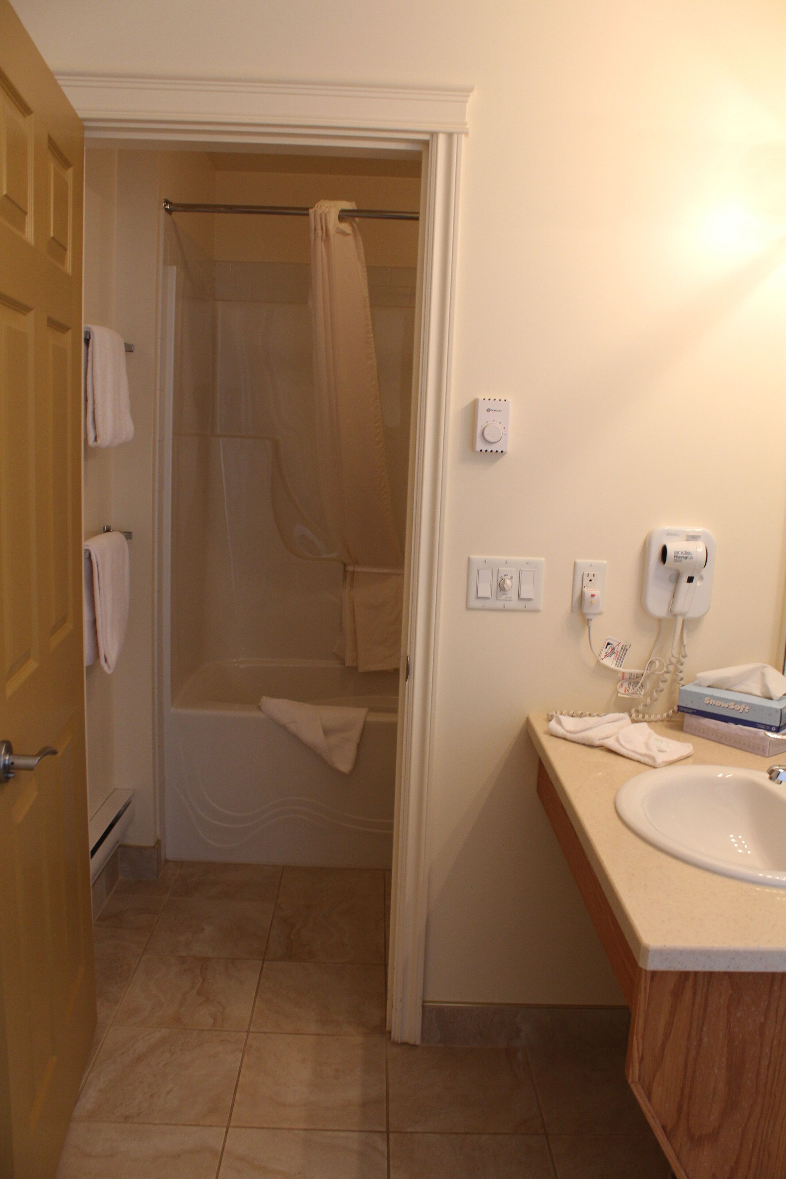 A bathroom with a shower, a sink, and a toilet.