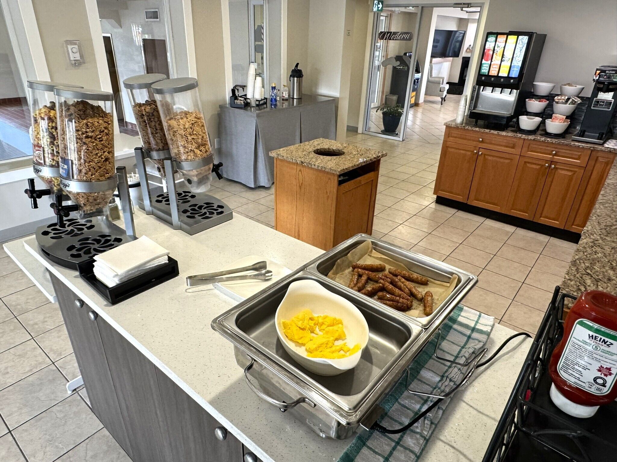 A buffet setup with various food items, utensils, and condiments.