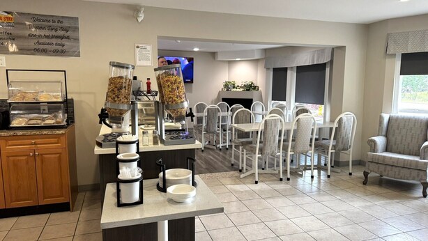 A breakfast area with a buffet setup, including cereal dispensers and a coffee station. - Western Budget Whitecourt 1 & 2 (Whitecourt)