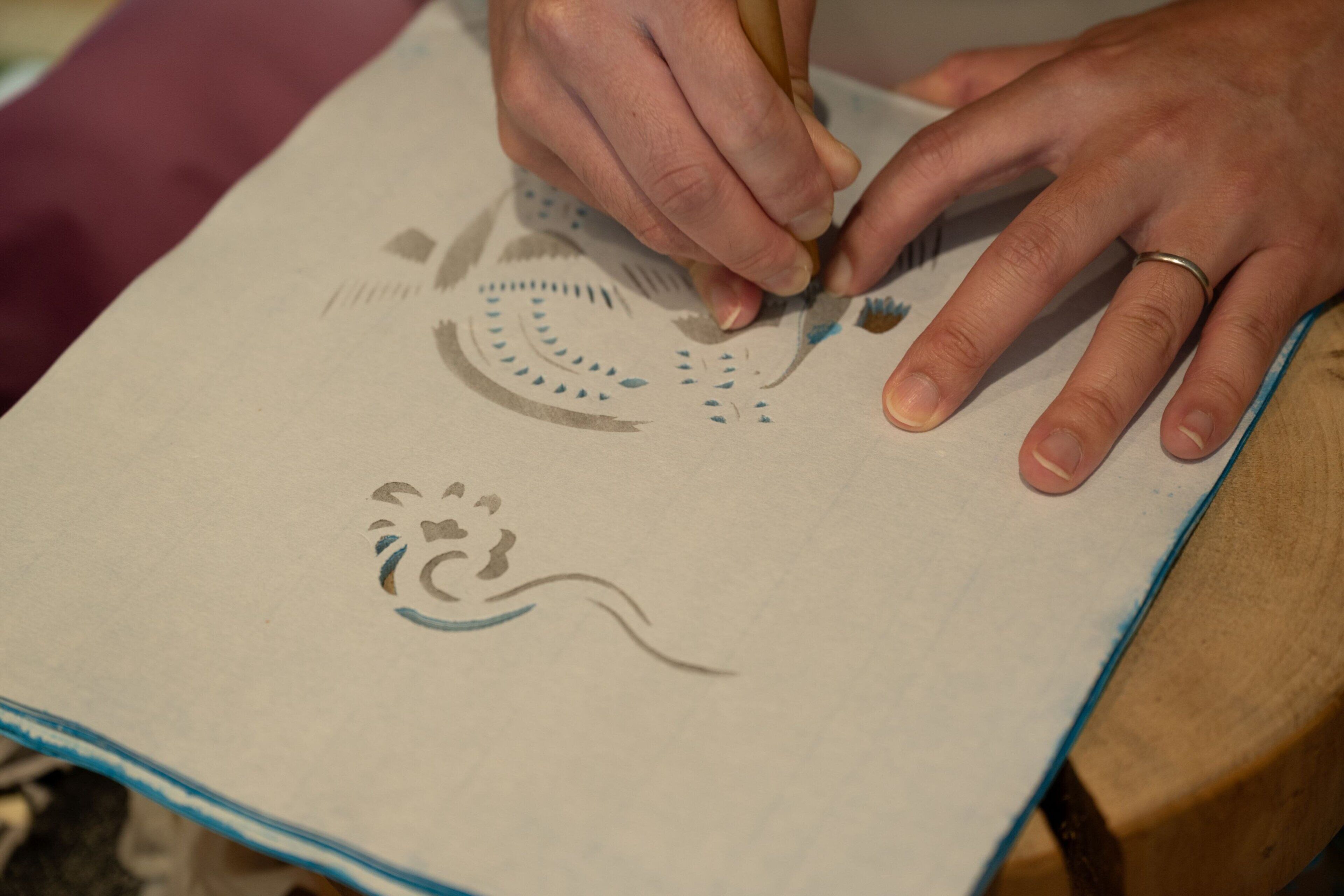 Una persona dibujando sobre un papel con un lápiz.