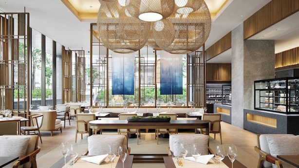 A modern restaurant with high ceilings, large windows, and a central dining area with tables and chairs. - JW Marriott Hotel Nara (Nara)