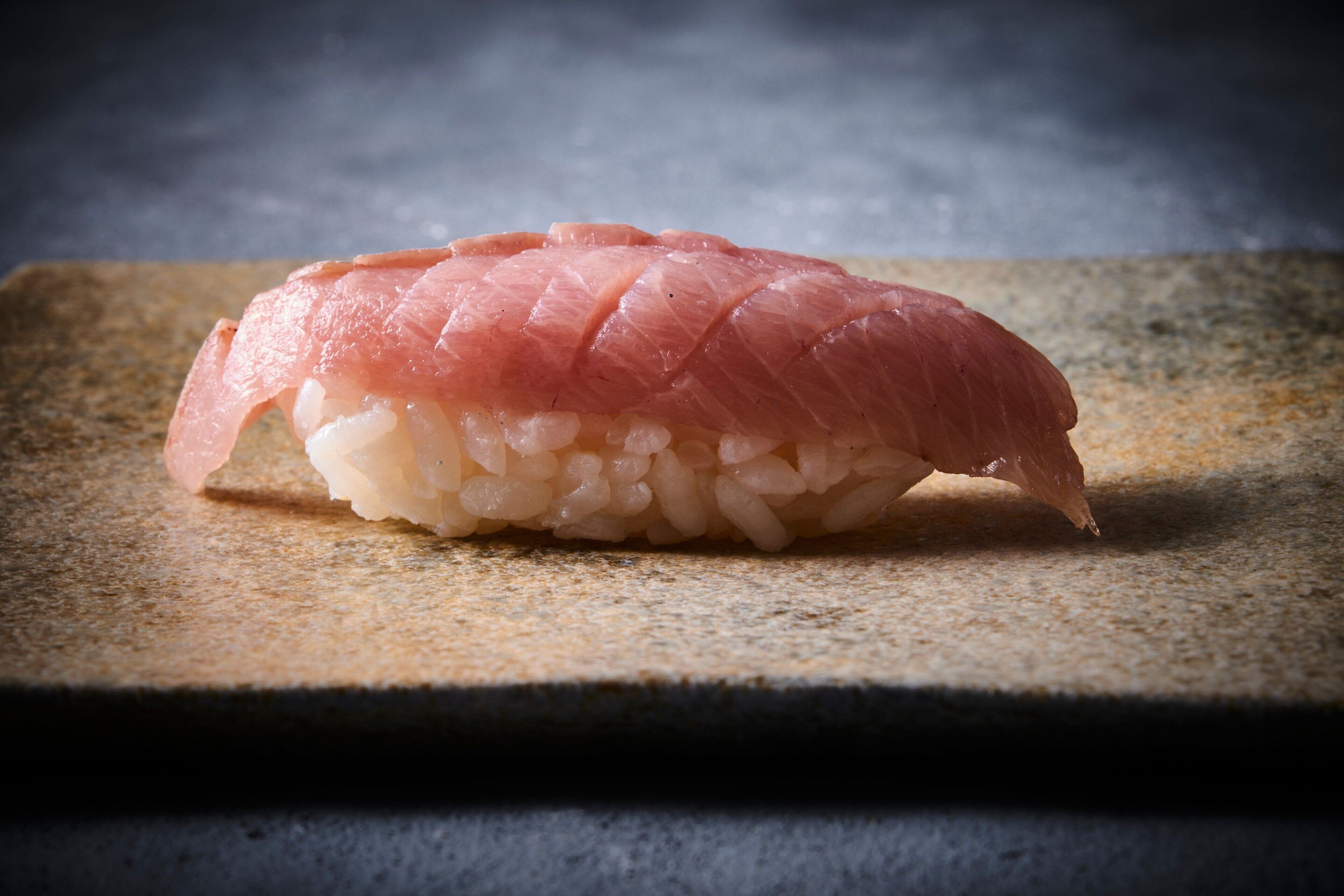 Un rollo de sushi sobre una superficie de piedra.