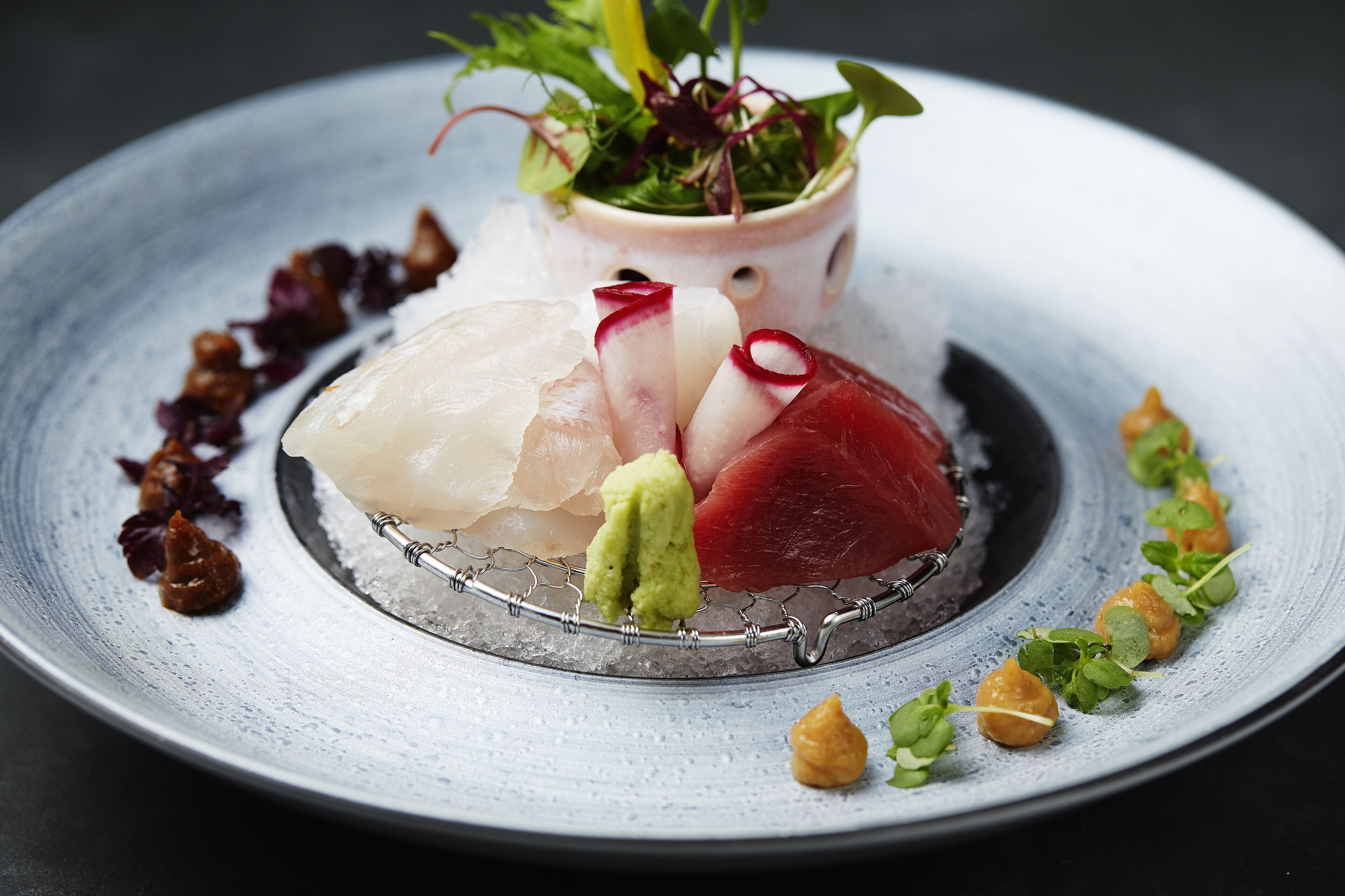 A plate of sushi with various types of fish and garnishes.