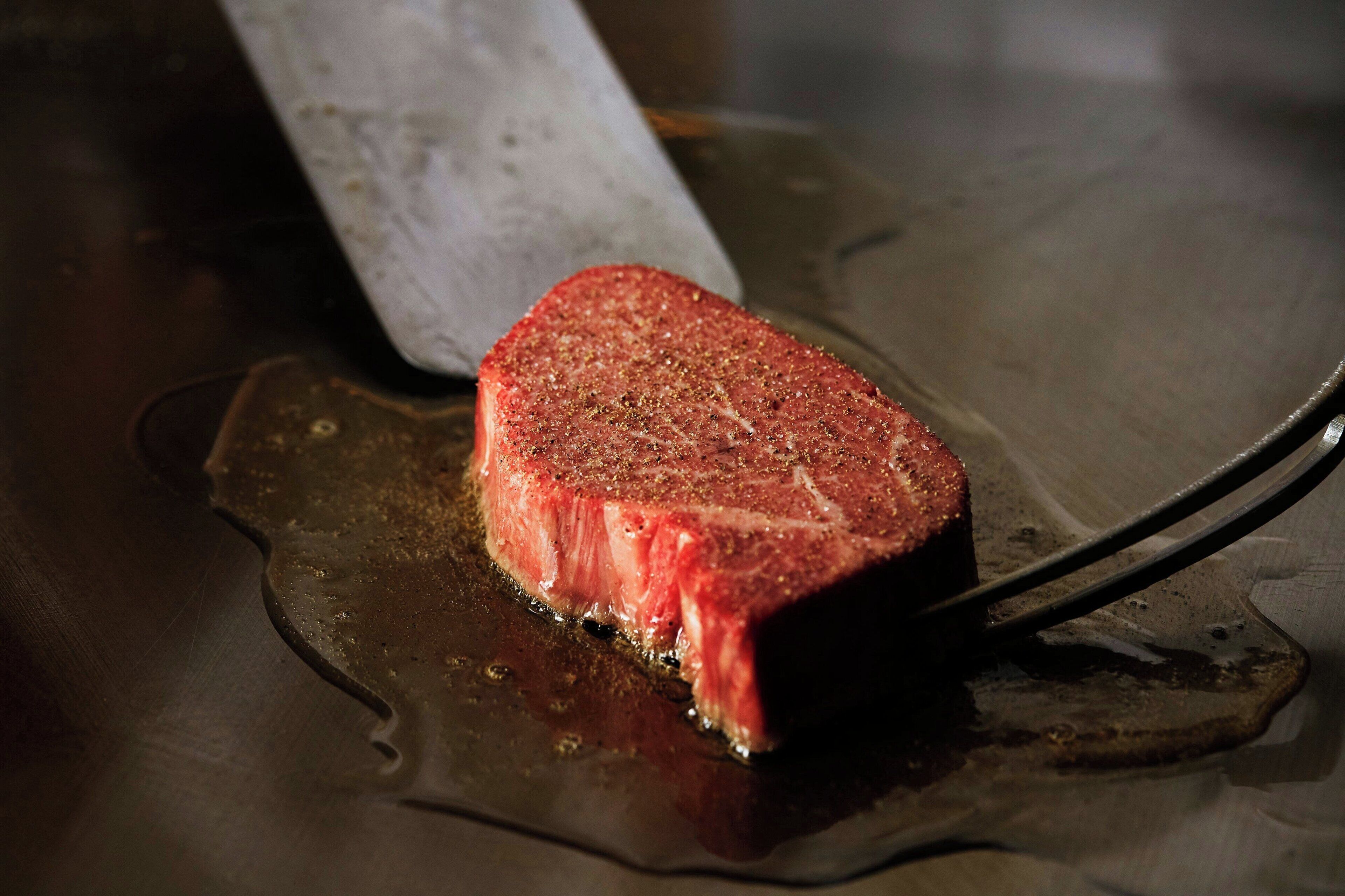 Een steak op een snijplank met een mes.