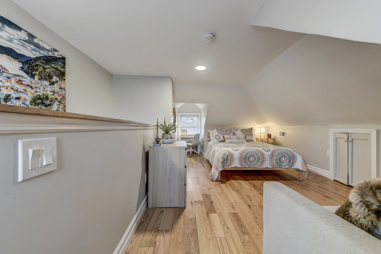 A bedroom with a bed, a desk, and a chair.