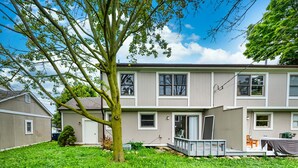 Ein zweistöckiges Wohnhaus mit Veranda und kleiner Terrasse.