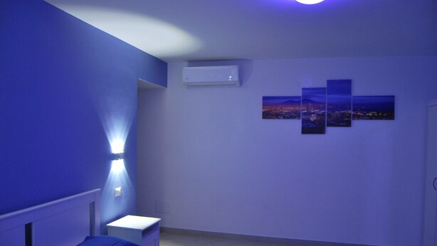 A bedroom with a bed, a nightstand, and a wall-mounted air conditioner. - in the real heart of Sorrento (Sorrento)