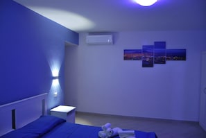 A bedroom with a bed, a nightstand, and a wall-mounted air conditioner. - in the real heart of Sorrento (Sorrento)