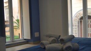 A hotel room with a bed, a window with a view of a building, and rolled towels on the bed. - in the real heart of Sorrento (Sorrento)