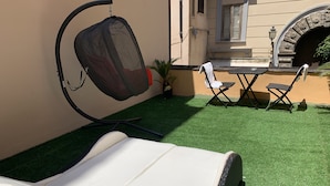 A sunbed in a covered outdoor area with artificial grass, a table, and two chairs. - in the real heart of Sorrento (Sorrento)