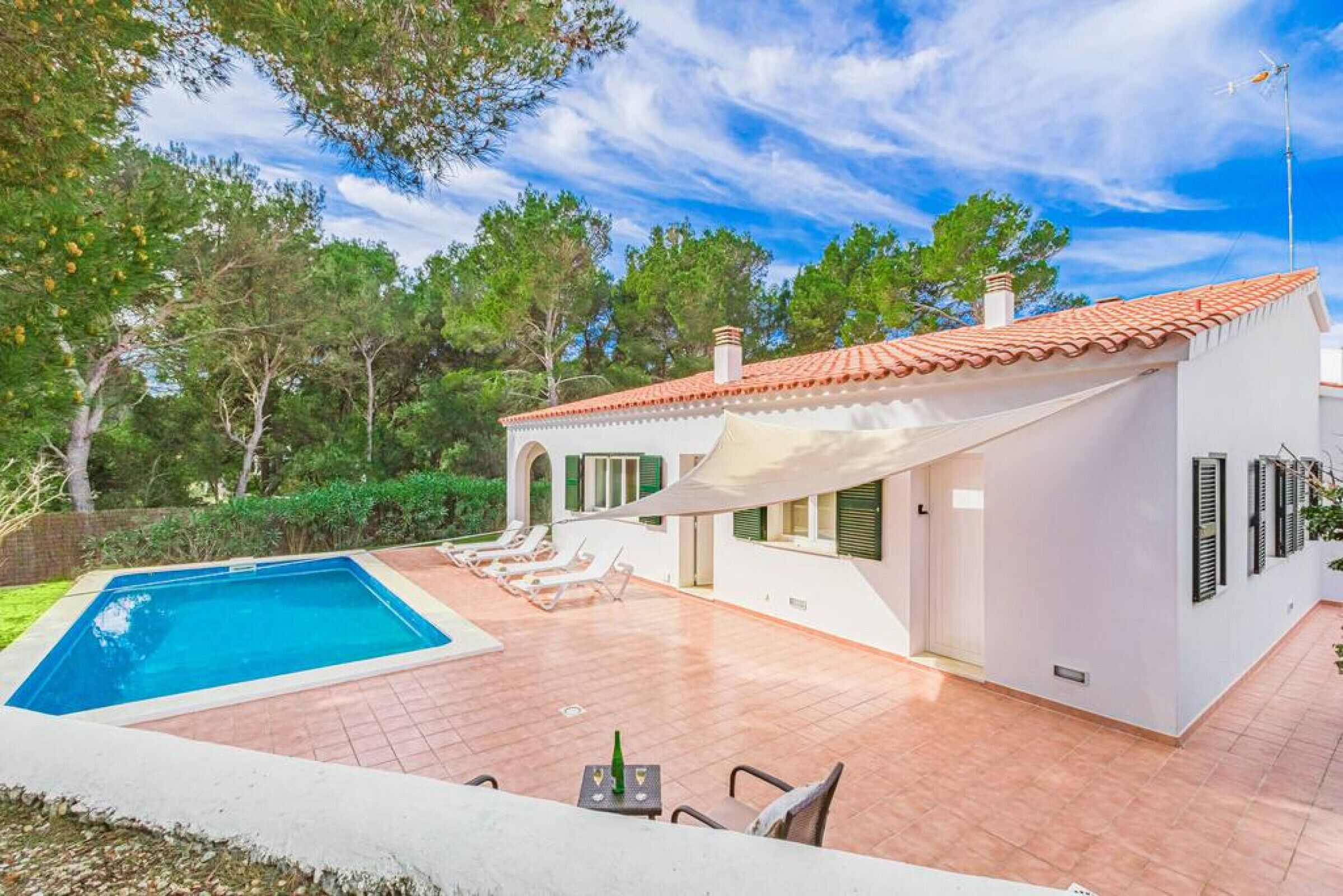 Une villa moderne dotée d’une piscine, d’un espace salon extérieur et d’un patio couvert.