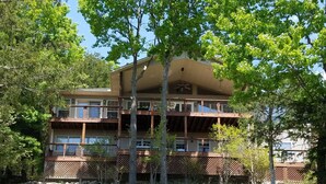 A multi-story building with balconies, surrounded by trees and a grassy area. - Fox Den- MAGNIFICENT Lake View! 5 minute walk or drive to shoreline!  (Garfield)