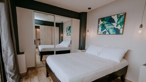 A bedroom with a large bed, a wardrobe, and a mirror. - Cozy Retreat with Breathtaking Views, 20 Minutes to the Airport (Alajuela)