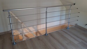 A metal safety railing in a room with wooden flooring and a sloped ceiling. - Holiday house 10 people in Binic (22) with Family or friends. (Binic)