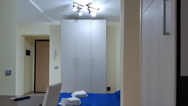 Ein Schlafzimmer mit Bett, Kleiderschrank, Schreibtisch und Stuhl.