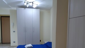 Ein Schlafzimmer mit Bett, Kleiderschrank, Schreibtisch und Nachttisch.