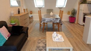 Un espacio habitable compacto con comedor, kitchenette y sofá.