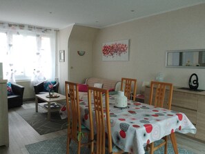 Una sala de estar acogedora con una mesa de comedor, sillas, un sofá y una mesa de centro.