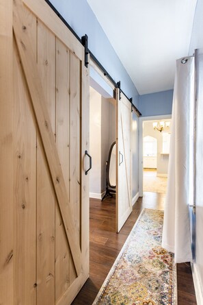 Double barn doors to bedroom with queen bed.