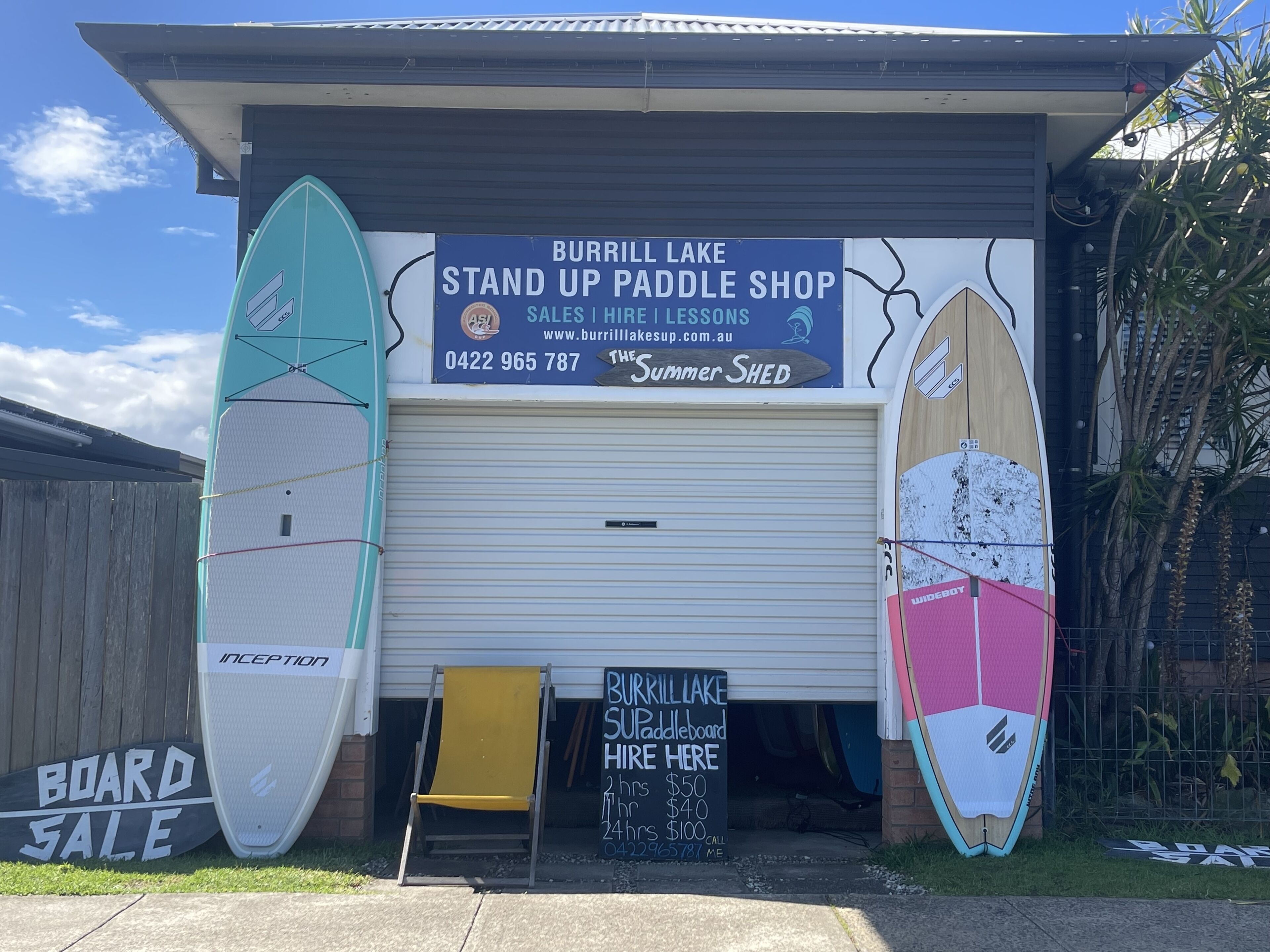 Negozio di pagaie con tavole da surf e un cartello che pubblicizza un'offerta sulle tavole.