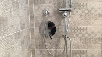 Ducha con cabezal de ducha de mano y grifo empotrado.