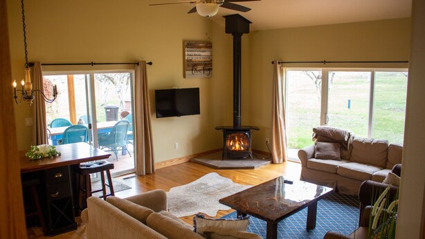 A living room with a fireplace, sofas, a coffee table, and a TV mounted on the wall. - Charming "Cherry House" (Rollins)