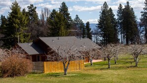 A cabin with a sloped roof, surrounded by a wooden fence and trees. - Charming "Cherry House" (Rollins)