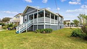 A two-story house with a front porch and a staircase leading to the entrance. - Tina Marie (Galveston)