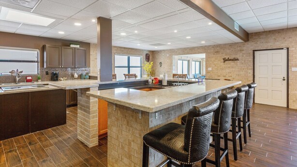 A spacious kitchen with a large island, bar stools, and a view of the city.