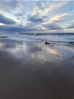 Ein Strand mit ruhigen Wellen und einem bewölkten Himmel.