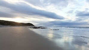 A beach with a wide sandy shore and a gentle slope leading to the water. - Taid's Retreat Silversands Cove Beach Lossiemouth (Lossiemouth)