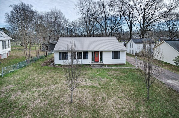 A single-story house with a red front door, a small front yard, and a metal fence. - 7 minutes from Providence Farm, MS Blues Trail and The Petrified Forest! (Flora)