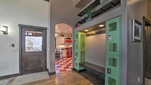 A hallway with wooden flooring, a dark wooden door, and green lockers. - Moab Getaway w/ Ample Parking, Walk to Main Street (Moab)