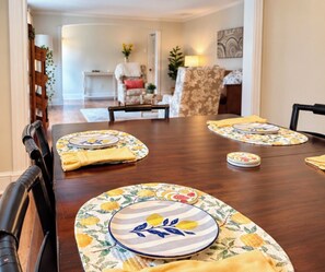 A dining table set with plates, napkins, and a placemat.