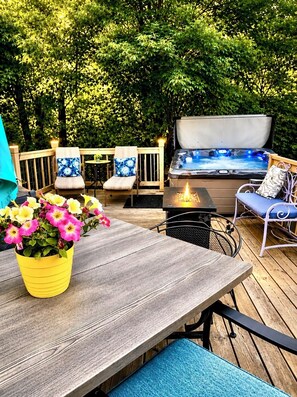 A wooden deck with a hot tub, outdoor seating, and a potted plant. - Rolling Hills Retreat ~King Bed,Hot Tub, Pool Table,Themed Movie Room,Woods view (Manitowoc)