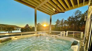 A hot tub under a wooden pergola with a view of a lake and sunset. - LAKEFRONT Mini-Resort Sleeps 32! Pool, hot tub, kayaks, fire pits, & more! (Cedar Bluff)