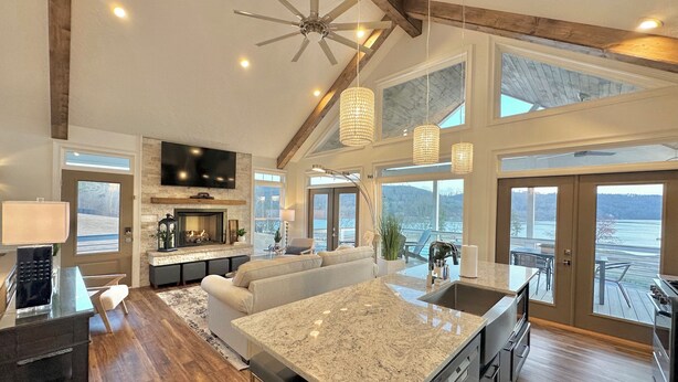 A spacious kitchen with a large island, a built-in oven, and a dining area with a view of the lake. - LAKEFRONT Mini-Resort Sleeps 32! Pool, hot tub, kayaks, fire pits, & more! (Cedar Bluff)