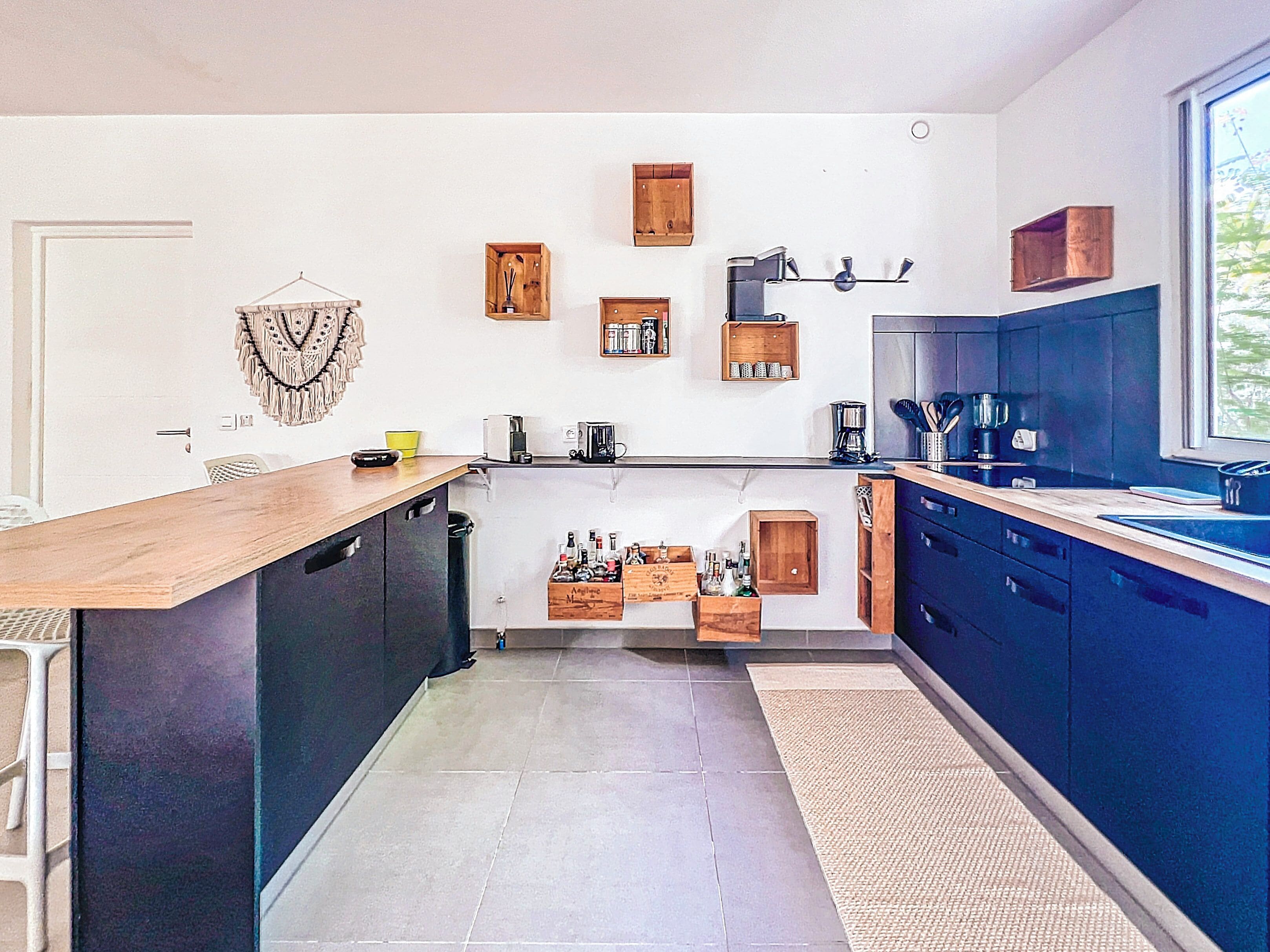 Een moderne keuken met een houten aanrecht, inbouwmeubels en een groot raam.