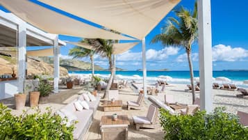 Rannalla, aurinkotuoleja, rantapyyhkeitä