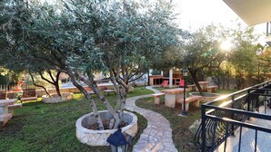A stone pathway leading through a landscaped area with benches and a tree. - Apartments Trstenica-One Bedroom Apartment with Terrace (Orebic)